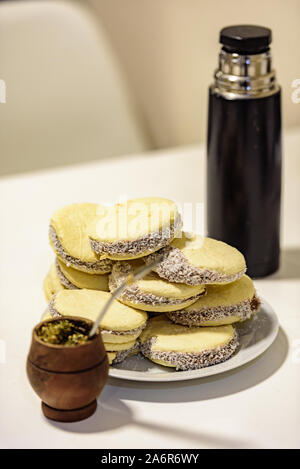 Mate und leckere argentinische und uruguayische Cookies alfajores mit Sahne auf Papier Nahaufnahme auf dem Tisch. Horizontal. Mate Drink traditionell in Urugua Stockfoto