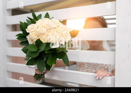 Blumenstrauß in der Hand der Braut auf einem unscharfen Hintergrund Stockfoto