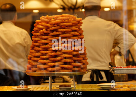 Frittierter Zuckerteig. Ein Haufen traditioneller Ringdessert - mit Sirup getränktes Gebäck - auf einem Ladendisplay in der Istiklal Avenue in der Türkei. Stockfoto