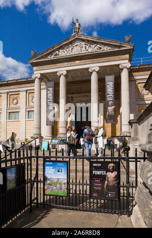 Eine Gruppe von Studentinnen und Sprechen auf den Stufen am Eingang des Ashmolean Museum, Oxford auf Beaumont Street im hellen Sonnenschein unter einem blauen Himmel Stockfoto