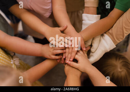 Kinder die Hände übereinander. Kinder- Team und unter den kleinen Kerlen. Stockfoto