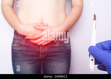 Arzt Chirurg hält ein Skalpell auf dem Hintergrund der Bauch eines Mädchens mit einem nabelbruch hernioplasty Chirurgie Konzept, Schmerzen Stockfoto