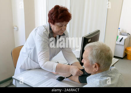 Sankt Petersburg, Russland - 19. Juli 2018. Stadt Poliklinik Nummer 103. Der Arzt misst den Blutdruck von einer älteren Person. Stockfoto