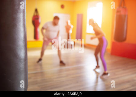 Boxing Sparring in der Ausbildung für Frauen und Mädchen, die unter der Aufsicht eines Martial Arts Trainer, Zeitlupe, Willenskraft, Kaukasier, verschwommen, individuell, s Stockfoto