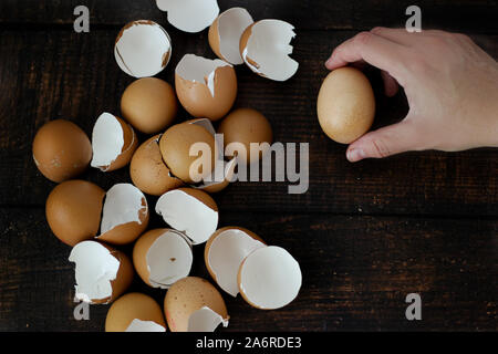 Hand braun Ei auf hölzernen Tisch Hintergrund Stockfoto