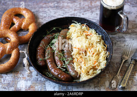 Bayerische Würste in einer Pfanne mit Schmorkohl. Oktoberfest essen. Selektive konzentrieren. Makro. Stockfoto