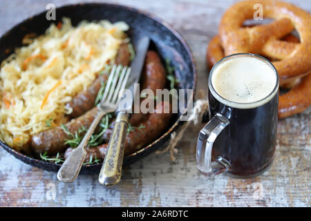 Bayerische Würste in einer Pfanne mit Schmorkohl. Oktoberfest essen. Selektive konzentrieren. Makro. Stockfoto