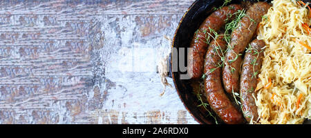 Bayerische Würste in einer Pfanne mit Schmorkohl. Oktoberfest essen. Selektive konzentrieren. Makro. Stockfoto