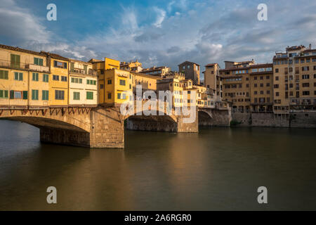 Seite Blick auf die Mittelalterliche steinerne Brücke Ponte Vecchio über den Arno in Florenz, Toskana, Italien. Blick vom degli Lungarno Archibusieri. Florenz ist ein beliebtes Reiseziel in Europa. Stockfoto