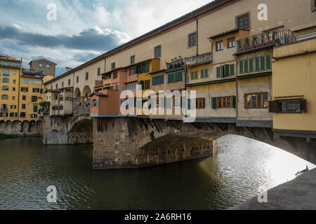 Seite Blick auf die Mittelalterliche steinerne Brücke Ponte Vecchio über den Arno in Florenz, Toskana, Italien. Blick vom degli Lungarno Archibusieri. Florenz ist ein beliebtes Reiseziel in Europa. Stockfoto