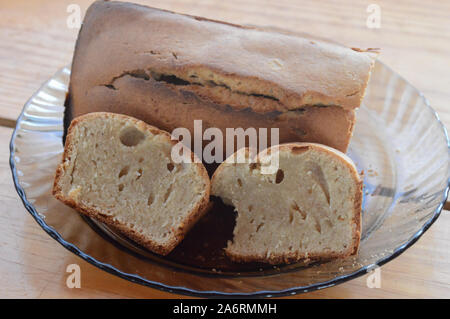 Hausgemachte Kuchen in Stücke schneiden, in eine Platte auf einem Holztisch Stockfoto