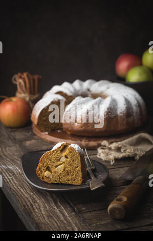 Landhausstil Apple Bundt Cake bestreut mit Puderzucker auf alten Holztisch Stockfoto