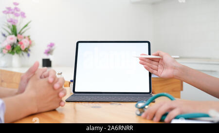 Arzt mit Tablet Diskussion etwas mit Patienten. Gesundheitswesen, Krankenhaus und Arzt Konzept. Kopieren Raum der Leere Computer und Tablet Bildschirm. Stockfoto