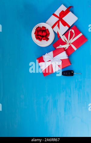 Geschenk-Konzept: Autoschlüssel mit blauen Geschenkbox mit rotem Band  isoliert auf weiss Stockfotografie - Alamy