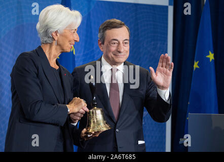 28. Oktober 2019, Hessen, Frankfurt/Main: Der scheidende Präsident der Europäischen Zentralbank, Mario Draghi (r), symbolisch den Vorsitz Hand zu seinem designierten Nachfolger, Christine Lagarde, mit einer Glocke in einer Zeremonie die Kennzeichnung den Wechsel an der Spitze der EZB. Foto: Boris Roessler/dpa Stockfoto
