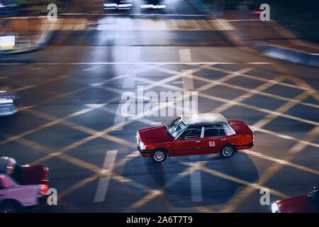 Nacht Blick auf rot Taxi Auto in Bewegung verwischt. In Hongkong Kreuzung. Stockfoto