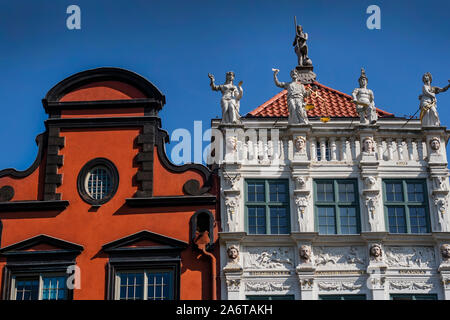 Oben auf alten historischen Wohnhäusern mit großen Skulpturen und Schnitzereien an der Lange Markt in Danzig, Polen Stockfoto