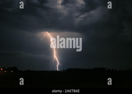 Helle verzweigte Blitzeinschlag in der Nähe einer Strom mast von einem schweren Gewitter in den Niederlanden Stockfoto