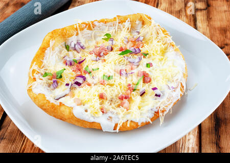 Langos mit Speck und Käse - Ungarische gebratener Teig essen Stockfoto