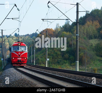 Zug im Herbst. Der Zug zieht bis zu der Plattform. Öffentlichen Verkehrsmitteln. Roten Zug nach Vilnius, Litauen ankommen. Travel Concept. Stockfoto