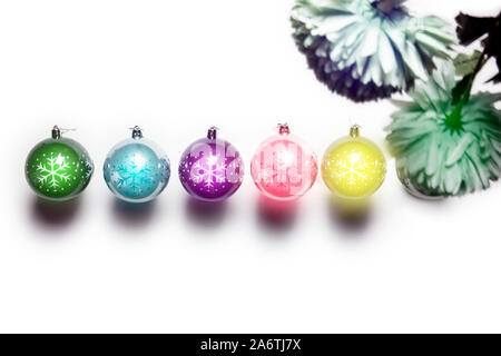 Weihnachten Kugeln auf Weiß, verschiedenen Neon Licht Farben isoliert, Weihnachtsdekoration Hintergrund Stockfoto
