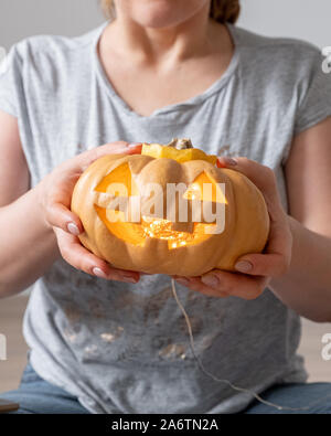 Weibliche Hände halten ein jack o lantern Kürbis für Halloween Stockfoto