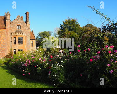 Chenies Manor House, die von der Anlage Grenze ausgestattet mit Dahlien, Kosmos und krautigen Pflanzen, Fenster nach Westen grenzt, an einem schönen Nachmittag. Stockfoto