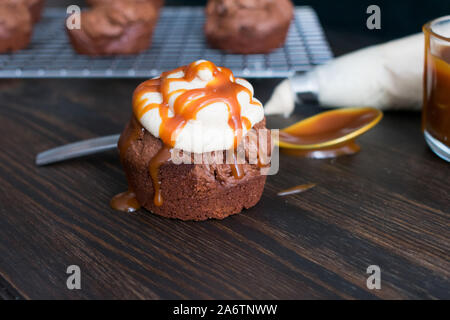 Baby Chai Karamell Fudgey Brownie Kuchen: Kleine Schokoladenkuchen Kuchen abgerundet mit Vanille chai Zuckerguss und gesalzen Karamell Sauce Stockfoto
