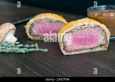 Einzelnen Beef Wellington mit Pilzsauce: Filet Mignon in Schinken gewickelt, cremini Pilz, und Blätterteig Stockfoto