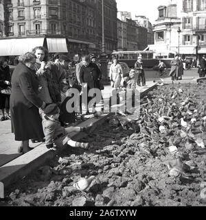 1950er Jahre, historisch, Menschen mit kleinen Kindern füttern die Tauben auf dem Platz vor dem Hotel de Ville, Paris, Frankreich, vor dem Rathaus. Stockfoto