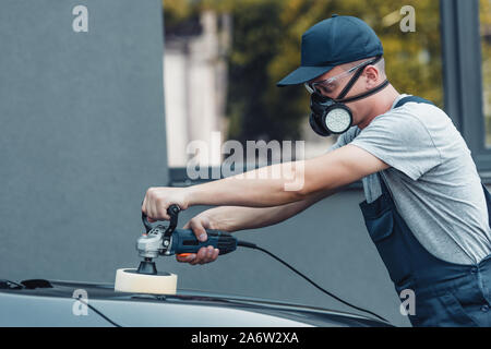 Junge Auto Reiniger polieren Auto mit polnischen Maschine Stockfoto