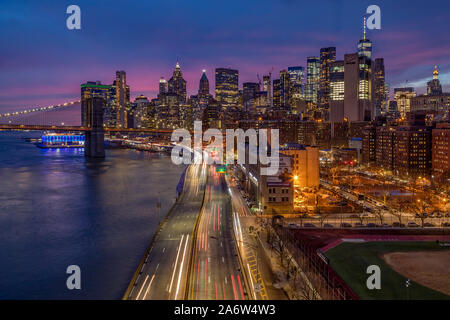 Brooklyn Bridge und Manhattan Skyline - Blick auf die Brooklyn Bridge, die FDR Highway und dem Finanzviertel während der blauen Stunde. Stockfoto