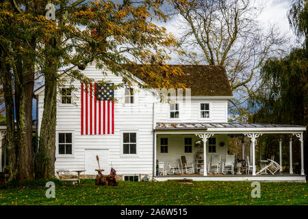Ländliche Amerika - zu einem patriotischen Land Home im Hudson Valley Gegend von New York, mit einem großen amerikanischen Flagge auf der Seite mit Veranda.