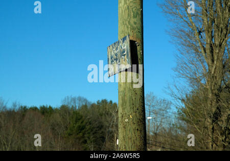 Eine alte verwitterte Auto abschleppen Services unterzeichnen auf Eine Heftklammer und Nagel enträtselt Telefonmast. Stockfoto