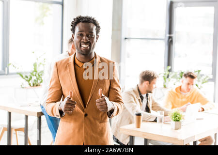 Fröhlich afrikanische amerikanische Geschäftsmann, Daumen hoch und lächelnd an Kamera Stockfoto