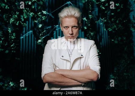 Blonder Mann tragen weiße Fashion Outfit auf dunklem Hintergrund. Stockfoto