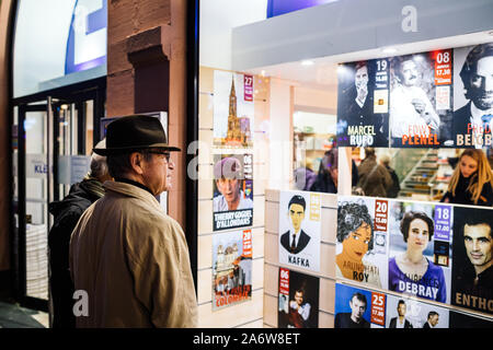 Straßburg, Frankreich - Dec 27, 2017: Seitenansicht des Schönen erwachsenen Mann, der klassische Hut, diverse Buchhandlung Ankündigung mit Autoren Anreisen zu singen Bücher Stockfoto