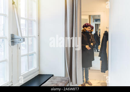 Frau innen stand Umkleidekabinen in der großen Frauen kleidung shop Messen neue warme Winter parka Stockfoto