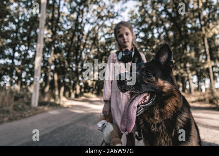 Selektiver Fokus der Deutsche Schäferhund in der Nähe von Kind mit Teddybär, post-apokalyptischen Konzept Stockfoto