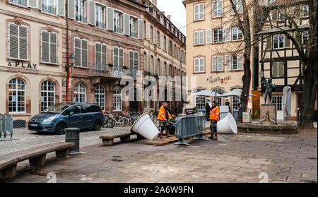 Straßburg, Frankreich - Dec 27, 2017: Arbeitnehmer, die die Weihnachtsdekorationen große weiße beleuchtete Vasen in französischer Sprache City Center in der Nähe von Piano Grill Bar Cafe Stockfoto