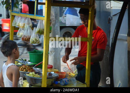 Ein Mann verkauft Gemüse und Obst in Street Market, Yangon, Myanmar. Stockfoto