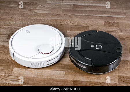 Zwei verschiedene Roboter Staubsauger veranschaulicht das Problem der Wahl Haushaltshelfer. Moderne smart Appliance für Reinigung Haus. Stockfoto