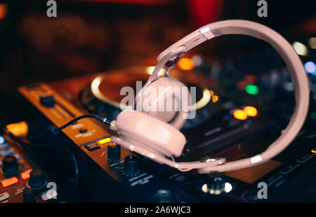 Closeup Paar beige Weiße Kopfhörer für DJ. cd mp4 Musik dj Mischpult Musik Party im Nachtclub. Club Konsole für Experimente mit Musik. Stockfoto