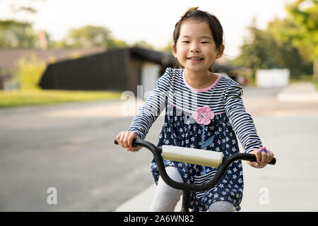 Süße kleine Mädchen lernen ein Fahrrad fahren ohne Helm Stockfoto