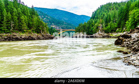 Die mächtigen Fraser River, mit der die bogenförmigen Stahlkonstruktion des Alexandra Brücke auf dem Trans Canada Highway in der Ferne in BC, Kanada Stockfoto