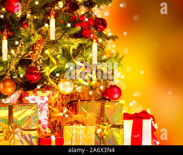 Geschmückten Weihnachtsbaum mit verschiedenen Gaben. Weihnachten und das neue Jahr feiern. Urlaub Weihnachten Szene. Weihnachten Geschenke unter dem Weihnachtsbaum Stockfoto