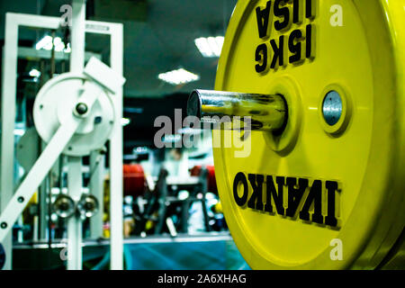 Professionelle yellow Hanteln und Hantelscheiben auf dem Hintergrund einer Fitness Gym. Sport Equipment. Stockfoto