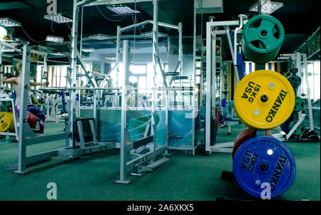 Professionelle Rot, Grün, Blau Hanteln und Hantelscheiben auf dem Hintergrund der Fitnessraum. Stockfoto