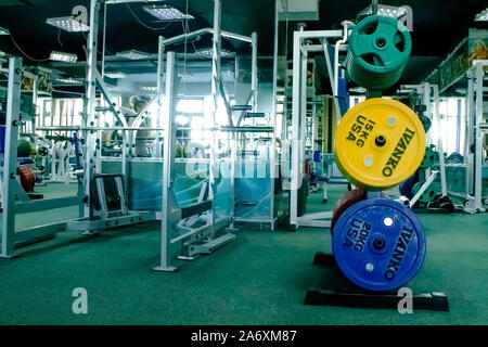 Professionelle Rot, Grün, Blau Hanteln und Hantelscheiben auf dem Hintergrund der Fitnessraum. Stockfoto