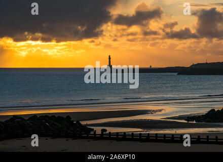 Aberdeen, Großbritannien. 29. Oktober 2019. UK Wetter: Das orange Leuchten der Sonne hinter Wolken über der Nordsee am Eingang zum Hafen Aberdeen vom Strand aus gesehen Stockfoto